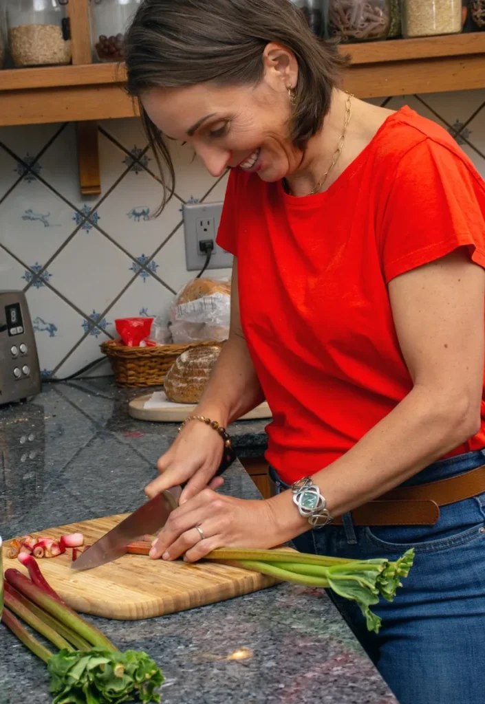 a woman cutting vegetables on a cutting board